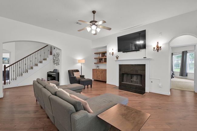 The custom built-in cabinetry and shelving, gas and wood burning fire-place, and elegant wall sconces create an inviting yet stylish ambience. | Image 11
