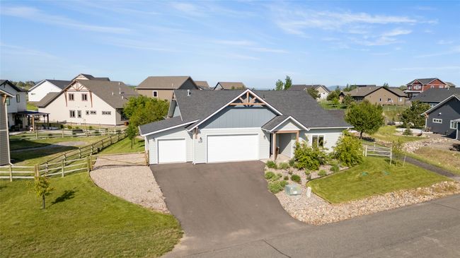 View of front of house with a residential view, board and batten siding, driveway, a garage, and a shingled roof | Image 49