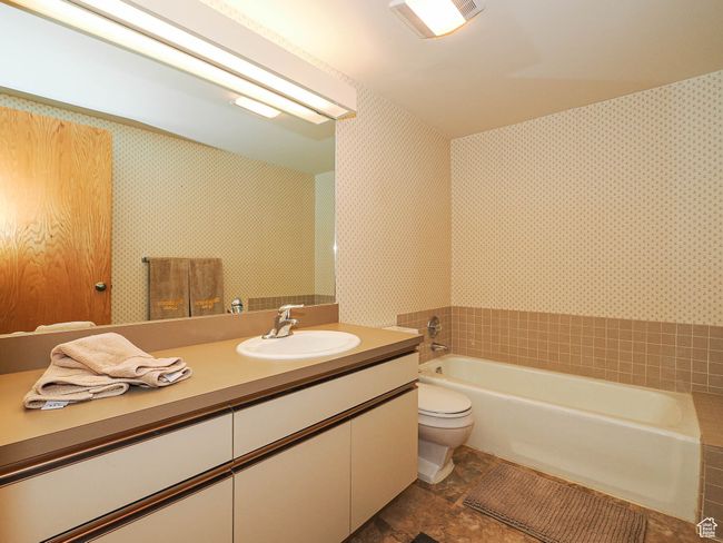 Full bathroom with a garden tub, vanity, and wallpapered walls | Image 50