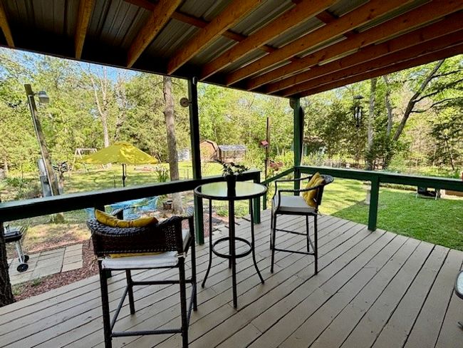 Wooden deck featuring outdoor dining area looking at the beautiful yard and garden area | Image 5