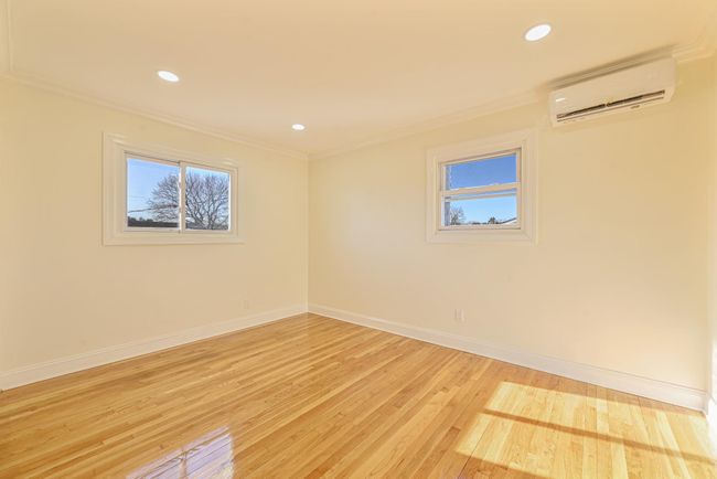 Spare room featuring ornamental molding, a wall unit AC, and light wood-type flooring | Image 33