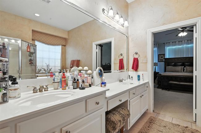 Ensuite bathroom with double vanity, tile patterned flooring, and a ceiling fan | Image 13