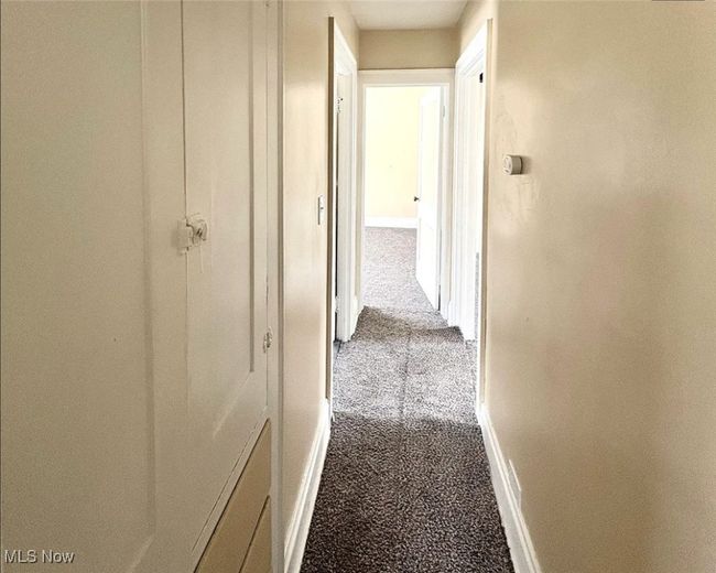 Hallway with baseboards and carpet | Image 7