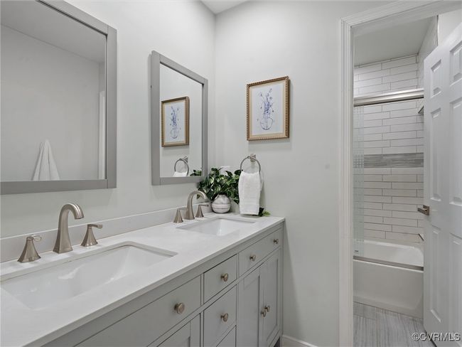 Full updated bath featuring double vanity and bathing tub / shower combination | Image 23