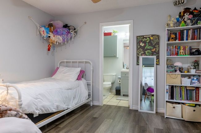 Bedroom featuring wood finished floors, ensuite bath, and baseboards | Image 13