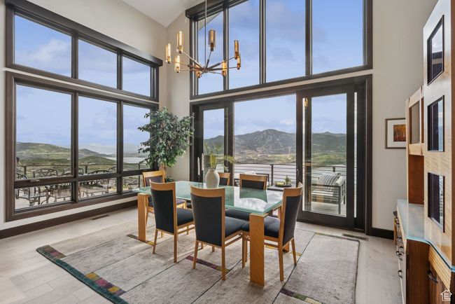 Dining space featuring a mountain view, healthy amount of natural light, a chandelier, light wood-style flooring, and a towering ceiling | Image 23