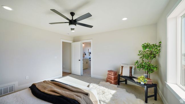 Bedroom featuring recessed lighting, light colored carpet, connected bathroom, ceiling fan, and multiple windows | Image 19