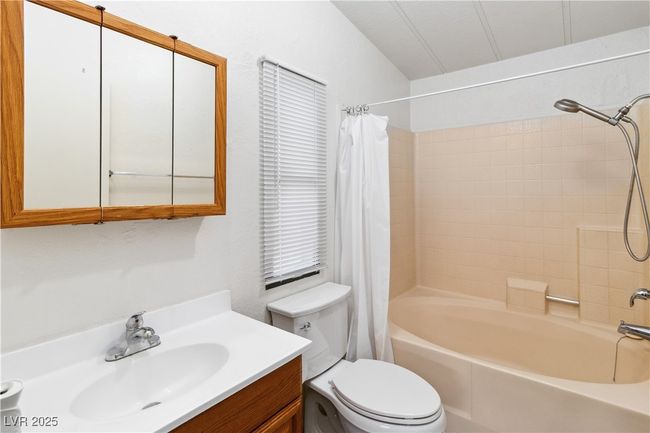 Full bath featuring toilet, shower / bathtub combination with curtain, and vanity | Image 23