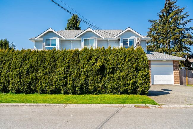View of front of home with fence, aphalt driveway, a shingled roof, and brick siding | Image 35
