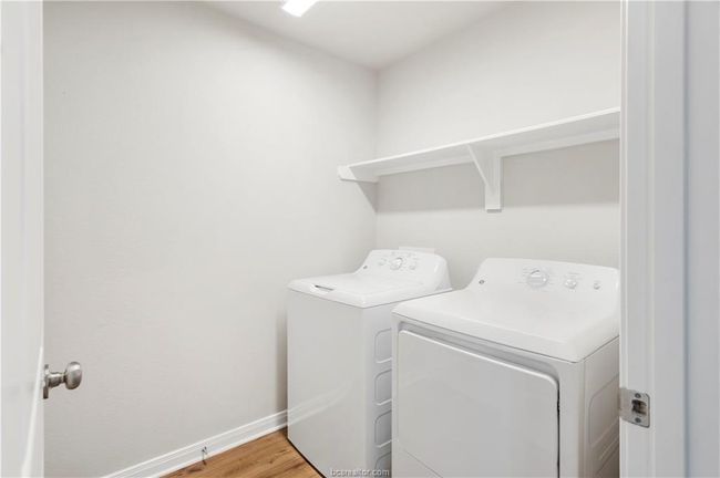Laundry area with washing machine and clothes dryer and light wood-style flooring | Image 19