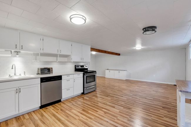 Kitchen featuring light wood-style flooring, stainless steel appliances, and a baseboard radiator | Image 25