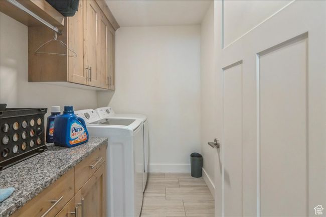 Laundry room with washer and clothes dryer, baseboards, light wood-type flooring, and cabinet space | Image 26