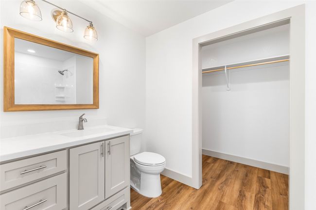 Full bathroom with toilet, vanity, wood finished floors, a spacious closet, and a shower | Image 21