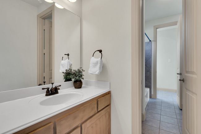 Full bathroom with vanity, tile patterned floors, and washtub / shower combination | Image 25