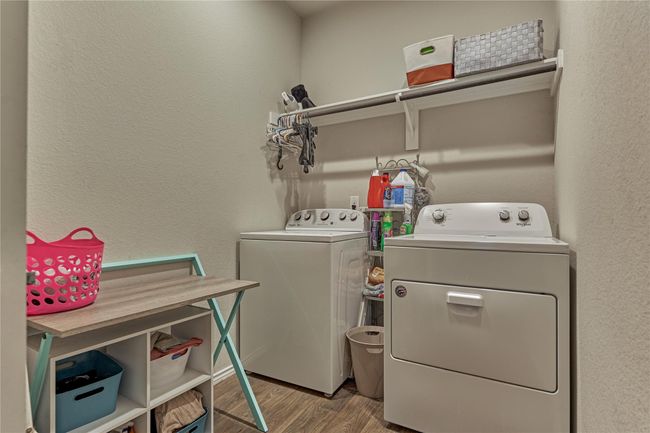 The laundry room features a clothing rack and storage shelf. | Image 36