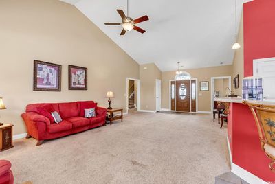 Carpeted living room featuring high vaulted ceiling and ceiling fan | Image 3