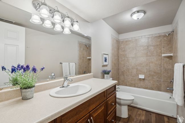 Full bathroom featuring toilet, vanity, hardwood / wood-style flooring, and tiled shower / bath | Image 31