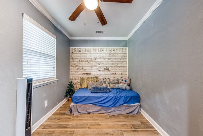 Bedroom with wood finished floors, ceiling fan, and ornamental molding | Image 17