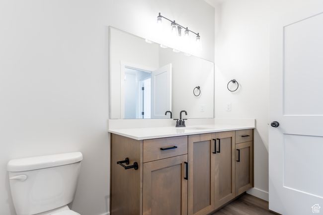 Bathroom featuring vanity, toilet, wood finished floors, and baseboards | Image 18