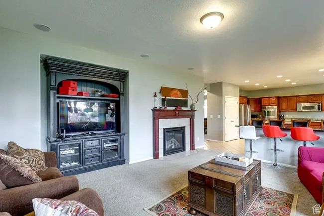 Living area with light carpet, a tile fireplace, and recessed lighting | Image 9