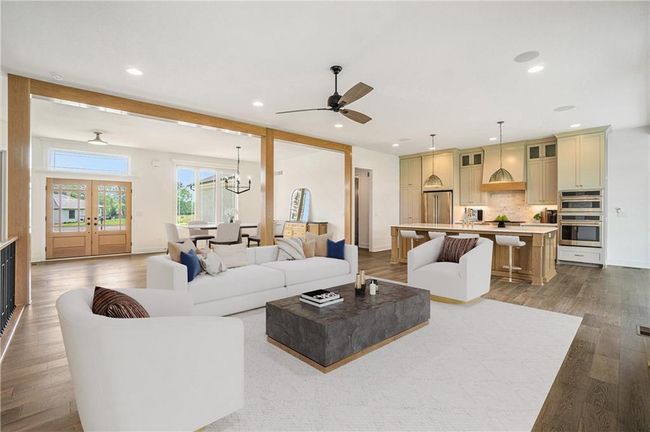 Living area featuring wood finished floors, ceiling fan, recessed lighting, a chandelier, and french doors | Image 17