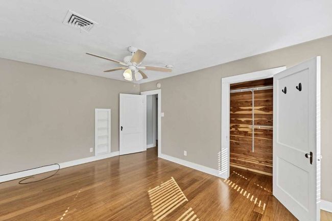 Unfurnished bedroom featuring visible vents, baseboards, a closet, and wood finished floors | Image 16