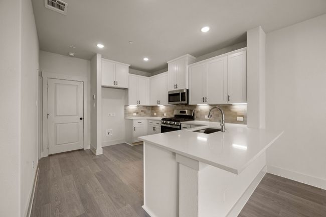 The oversized kitchen peninsula offers the perfect place for a quick meal. | Image 7