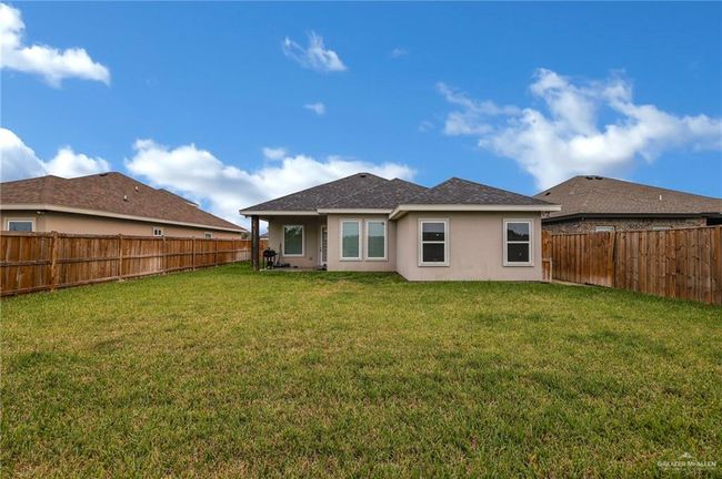 Back of property with a lawn, a shingled roof, stucco siding, and a fenced backyard | Image 20