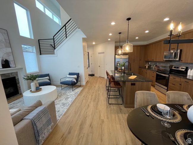 Kitchen with appliances with stainless steel finishes, brown cabinetry, a kitchen bar, a sink, and tasteful backsplash | Image 4