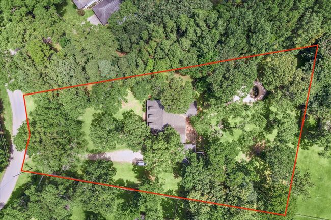 Charming two-story home with a welcoming front porch, nestled among mature trees. Features dormer windows, a classic gable roof, and a spacious yard, perfect for enjoying nature and outdoor activities. | Image 16