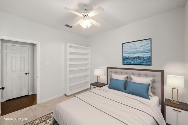 This seconary bedroom has updated ceiling fan, recently updated carpet, a built in shelving unit and nice size closet. | Image 36