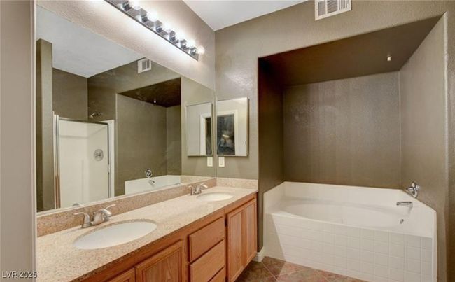 Bathroom with visible vents, walk in shower, a bath, and a sink | Image 13