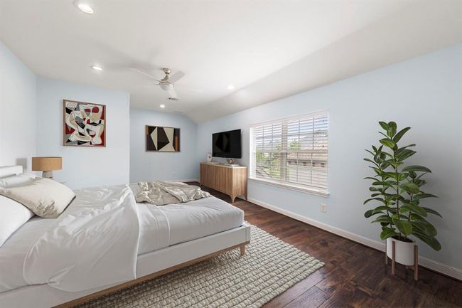 This suite style upstairs bedroom offers rich hardwood floors, serene natural light, and a vaulted ceiling—perfect for a peaceful retreat. *This photo has been virtually staged.* | Image 35