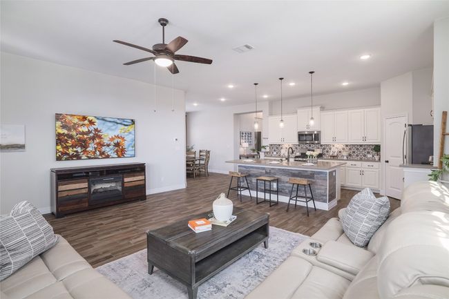 Living room with ceiling fan and dark wood-style floors | Image 4