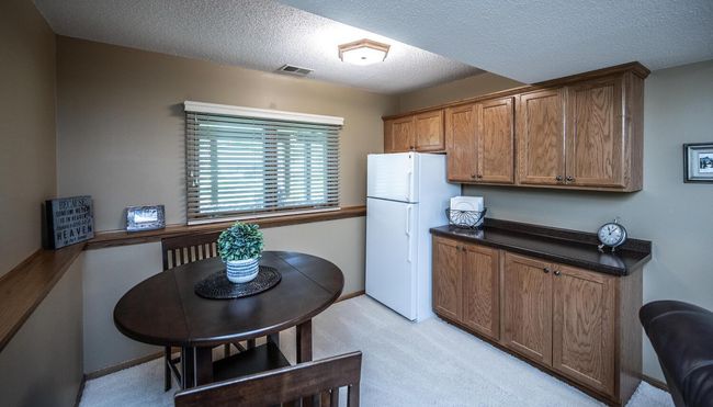 View of family room game & table area with convenient built-in counter space, cabinets & refrigerator. | Image 29