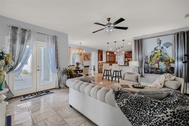 Living room featuring french doors and ceiling fan with notable chandelier | Image 16