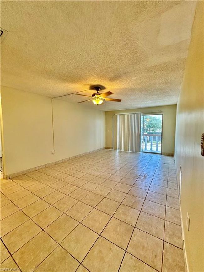 Spare room featuring light tile patterned floors, ceiling fan, and a textured ceiling | Image 5