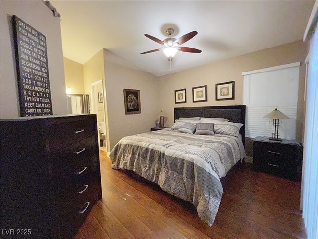 Bedroom with wood finished floors, a ceiling fan, and lofted ceiling | Image 15