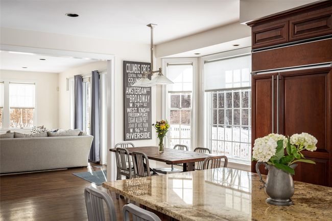 Dining space with large windows, featuring dark hardwood flooring with view into great room | Image 10
