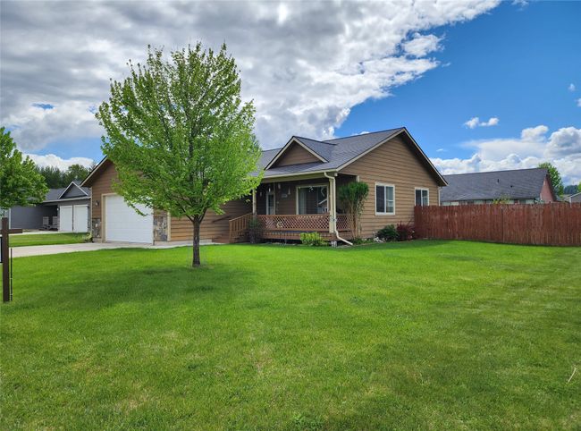 Ranch-style house with covered porch, driveway, and an attached garage | Image 51