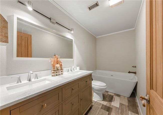 Full bathroom featuring crown molding, a soaking tub, double vanity | Image 22
