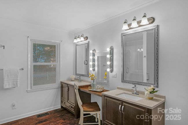 Luxurious primary suite bath offering double vanities and a custom-lit makeup space | Image 22