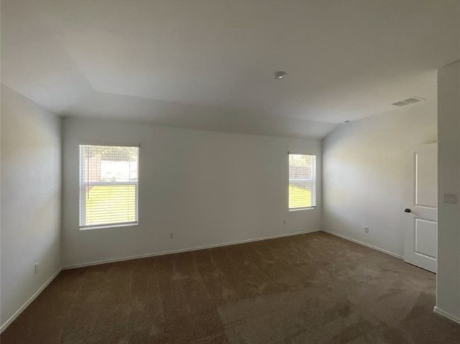 Empty room featuring carpet flooring, baseboards, and lofted ceiling | Image 19