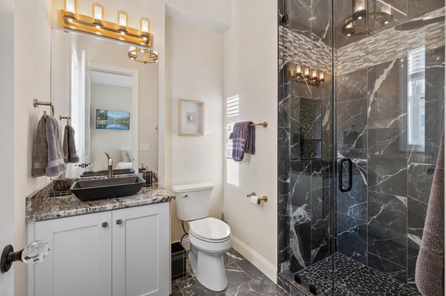 Private retreat with a walk-in shower and custom tile surround ensures comfort and convenience on the main level. | Image 15