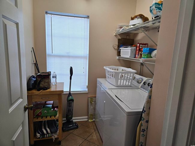 Laundry area featuring washer and dryer and tile patterned floors | Image 11