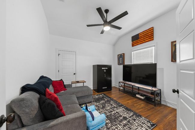 Living room with ceiling fan, vaulted ceiling, wood finished floors, and baseboards | Image 16