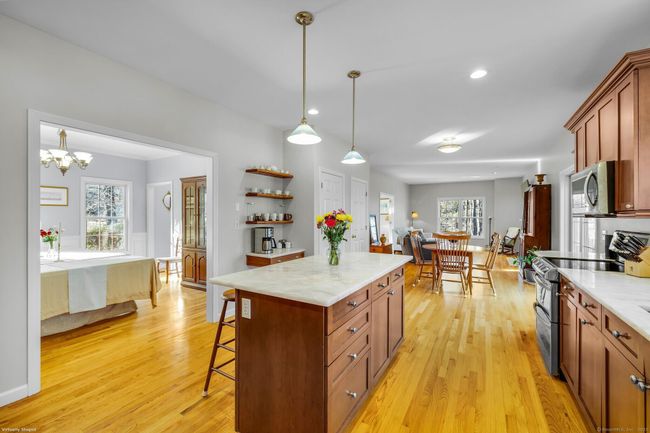 Remodeled kitchen with hardwood flooring, center island, marble countertops, pendant &amp; recessed lighting, pantry and custom built-ins. | Image 8