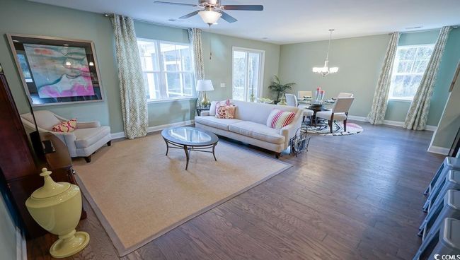 Living room featuring baseboards, a ceiling fan, wood finished floors, and plenty of natural light | Image 9