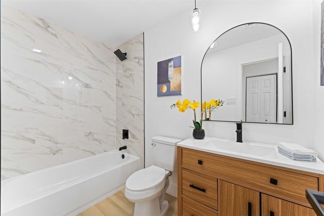 Bathroom featuring vanity, bathtub / shower combination, and wood finished floors | Image 18
