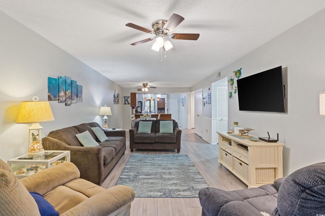Living room with ceiling fan and light wood-type flooring | Image 16
